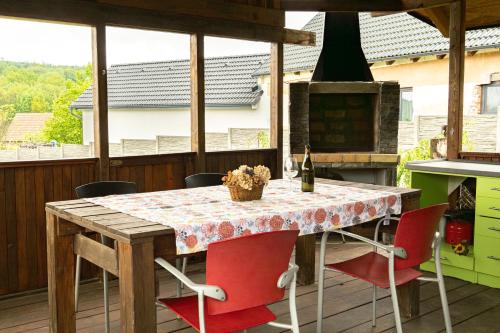 a kitchen with a table with red chairs and a stove at Chaloupka nedaleko Monínce in Sušetice