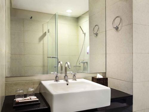 a bathroom with a sink and a mirror at Ibis Styles Solo in Solo