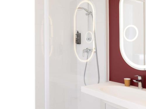 a bathroom with a shower and a white sink at ibis Valenciennes in Valenciennes