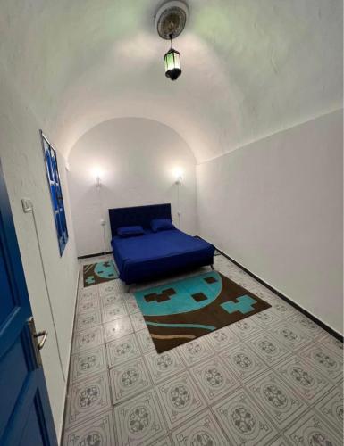 a small bedroom with a blue bed and a carpet at Maison vue mer in Rafrāf