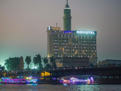 a hotel with a clock tower on top of a building at Novotel Cairo El Borg in Cairo