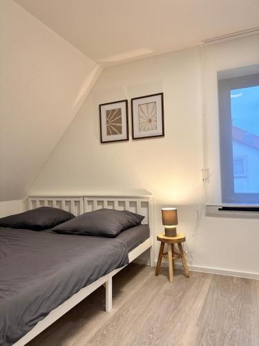 a bedroom with a bed and a window and a chair at Modernes Apartment am Bodensee in Singen