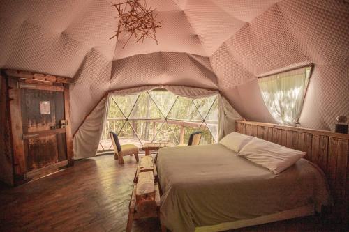 a bedroom with a bed in a tent at El Escondido Natural Glamp in Atos Pampa