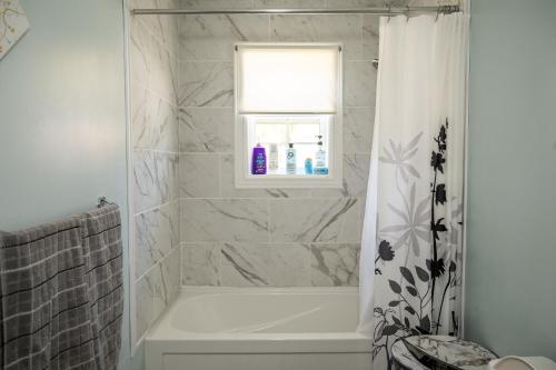 ein Badezimmer mit Badewanne und Fenster in der Unterkunft Exceptional Ocean View Hillview in Northern Bight