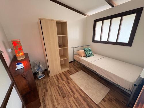 a small bedroom with a bed and a window at Fare Maeva in Paopao