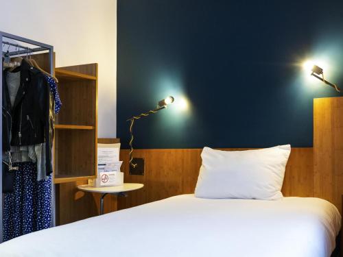 a bedroom with a bed and a blue wall at ibis Styles Nancy Centre Gare in Nancy