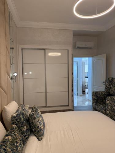 a bedroom with a bed and a chair and a window at Cozy appartement smir park in Tétouan