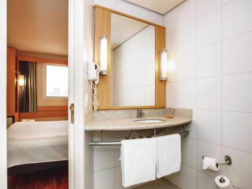 a bathroom with a sink and a mirror at Ibis Belo Horizonte Savassi in Belo Horizonte