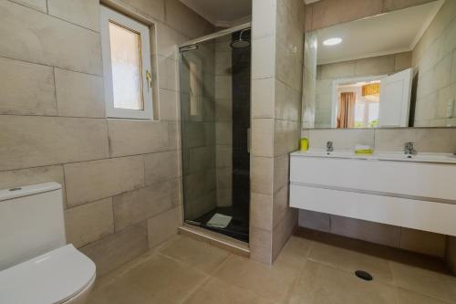 a bathroom with a shower and a toilet and a sink at Villa Ursa by Algarve Holidays in Praia do Carvoeiro