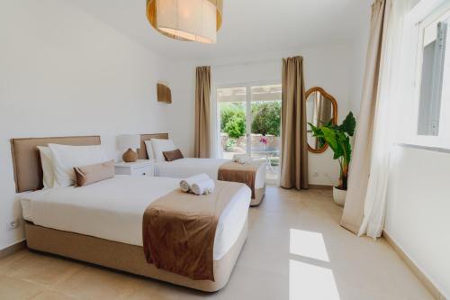 a bedroom with two beds and a large window at Villa Ursa by Algarve Holidays in Praia do Carvoeiro
