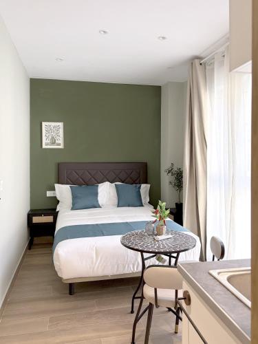 a bedroom with a bed and a table and a sink at Feliz Apartment in Madrid