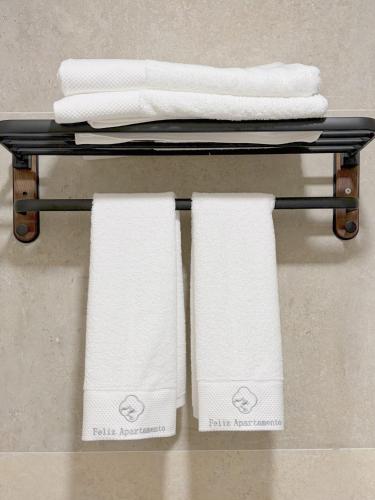 a towel rack with white towels on it at Feliz Apartment in Madrid