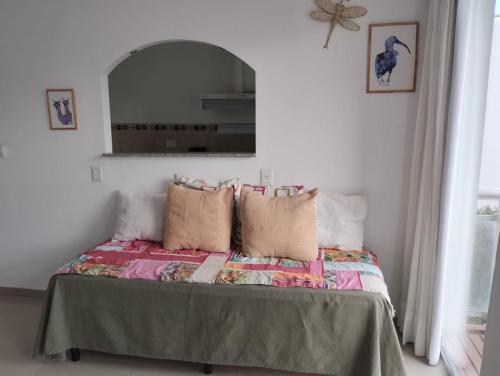 a bedroom with a bed with pillows and a mirror at APA Centro 2505 - con hidromasaje in Puerto Madryn