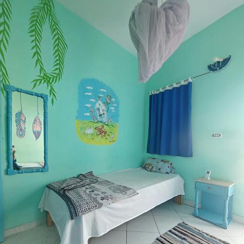 a bedroom with a bed and a blue wall at blue Bird in Nuweiba‘ el Muzeinah