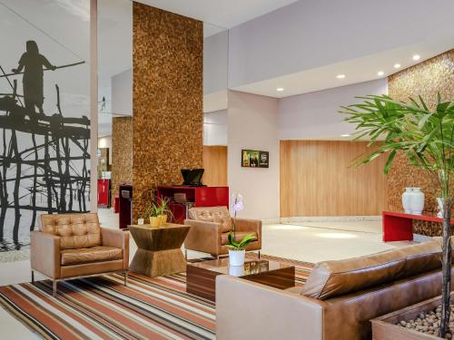 a lobby with couches and chairs and a table at Mercure Salvador Boulevard Hotel in Salvador