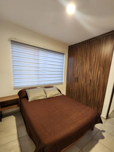 ein Schlafzimmer mit einem Bett und einem großen Fenster in der Unterkunft Depa Piky in La Cañada