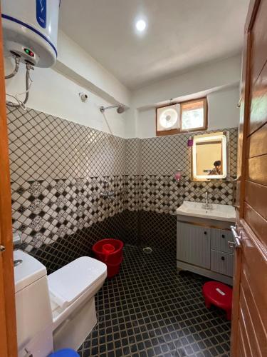 a bathroom with a toilet and a sink and a mirror at Sunset Lagoon Dalhousie in Dalhousie