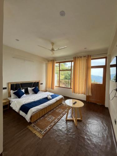 a bedroom with a bed and a table and windows at Sunset Lagoon Dalhousie in Dalhousie