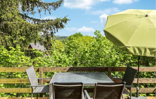 a table and chairs with a green umbrella at 2 Bedroom Nice Home In Bad Lobenstein in Bad Lobenstein