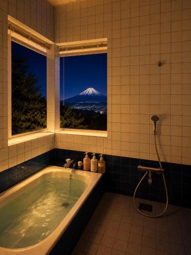 a bathroom with a tub with a view of a mountain at Fuji Nest Izu in Izunokuni
