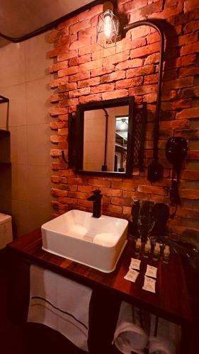 a bathroom with a sink and a brick wall at Hotel Van Gogh Aeropuerto Gdl in Guadalajara