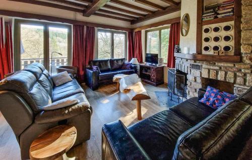 a living room with leather furniture and a fireplace at Le Petit Verger in Waimes