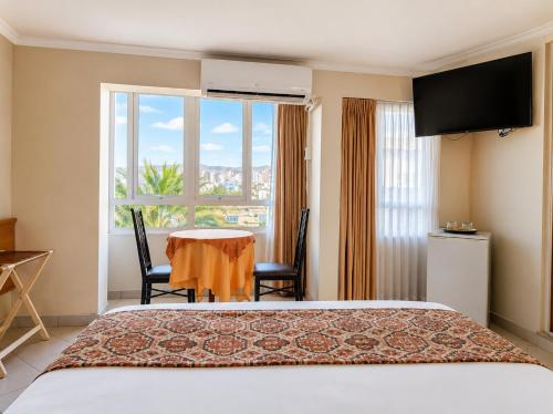 a hotel room with a bed and a table and a window at Hotel Premier in Tacna