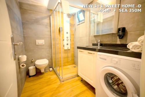 a bathroom with a shower and a washing machine at Camyuva Beach Hotel in Kemer