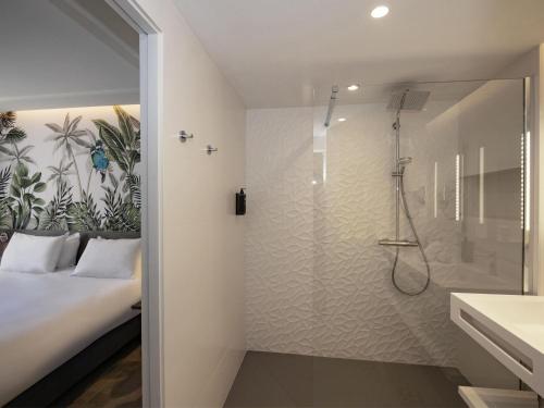 a master bathroom with a shower and a bed at ibis Styles Beaulieu sur Mer in Beaulieu-sur-Mer