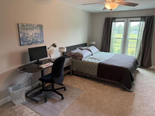a bedroom with a bed and a desk with a computer at Tide's Turn Retreat in Cedar Point