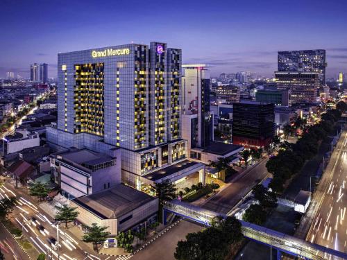 a tall building with a sign on it in a city at Grand Mercure Jakarta Harmoni in Jakarta