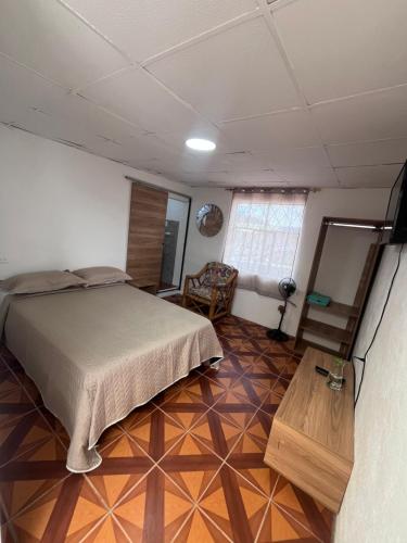 a bedroom with a bed and a wooden floor at Alojamiento Mujer Dormida in Ambuquí