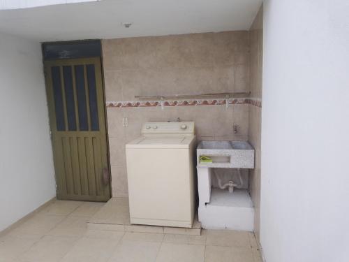 a small kitchen with a stove and a refrigerator at hospedaje dorado engativá in Bogotá