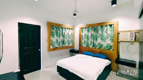 a bedroom with a bed and a black door at PNS BORACAY Station 1 in Boracay
