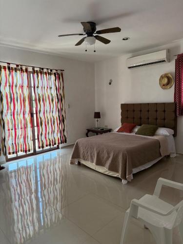 a bedroom with a bed and a ceiling fan at Gated house with garden and pool Mérida in Caucel