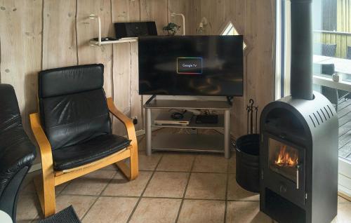 a living room with a wood stove and a chair at 3 Bedroom Amazing Home In Haderslev in Haderslev