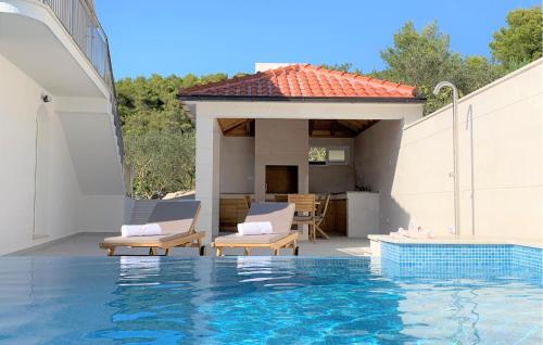 a swimming pool with two chairs and a house at Villa Beachfront Korcula in Vela Luka