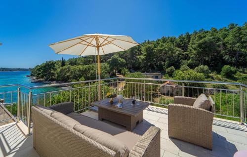 a patio with a table and an umbrella at Villa Beachfront Korcula in Vela Luka