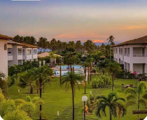 a view of a resort with a pool and palm trees at Apartamento térreo com 3 quartos no Tree Bies- próximo do parque aquático infantil in Subaúma