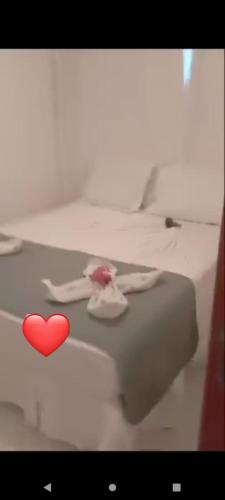 a red heart on top of a white bed at Apartamento térreo com 3 quartos no Tree Bies- próximo do parque aquático infantil in Subaúma