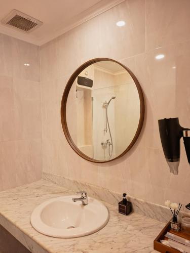 a bathroom with a sink and a mirror at Hotel Butik Sawunggaling in Bandung