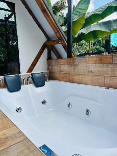 a room with two blue chairs and a bath tub at FINCA HOTEL GUADUAL Quindío in Quimbaya