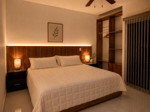 a bedroom with a large bed with two night stands and two lamps at Lucmar Jardín boutique in Cuernavaca
