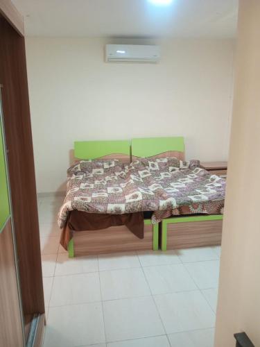 a bedroom with a bed with a quilt on it at عمان in Az Zarqa