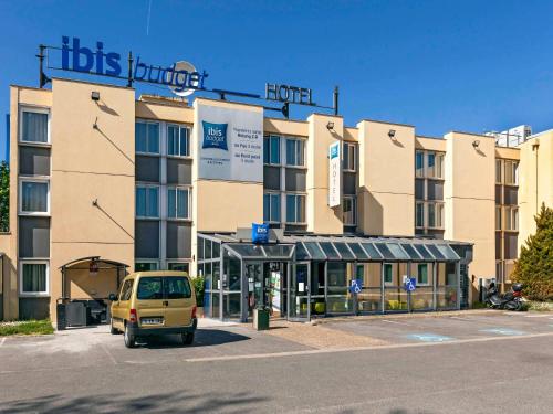 a yellow van parked in front of a building at ibis budget Antony Massy rénové 2024 in Antony