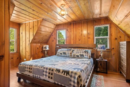 a bedroom with a bed in a room with wooden walls at SPSL Lake Arrowhead llc in Lake Arrowhead