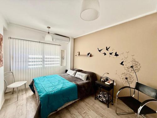 a bedroom with a bed and birds on the wall at Mini departamento LUMIC II in Santa Fe