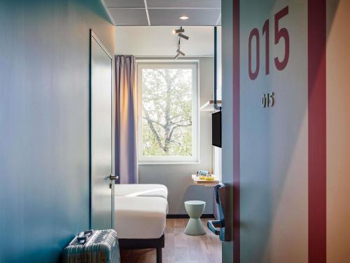 a small room with a bed and a window at Ibis Budget Cergy St Christophe in Cergy