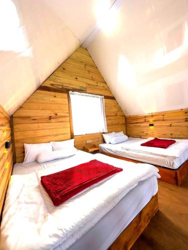 a bedroom with two beds in a log cabin at Villa Celyn Dieng cabin in Diyeng