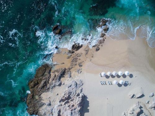an aerial view of a beach with five chairs at Club Regina Los Cabos in San José del Cabo
